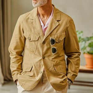 A man wearing a Camel Beige Ripstop Cotton Bush Jacket from Manifattura Ceccarelli and sunglasses.