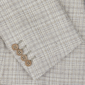 A close-up of a Canali Beige Melange Silk Wool Basketweave Blazer with four round, brown buttons aligned diagonally near the bottom left.