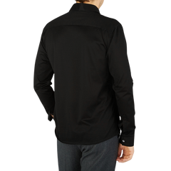 The back view of a contemporary man wearing a black Canali Black Cotton Jersey Casual Shirt.