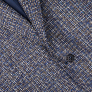Close-up of a Blue Melange Silk Wool Basketweave Blazer in blue-brown and beige tweed fabric by Canali with a visible button and part of a dark lapel.