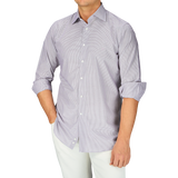 A man wearing a purple Canali shirt and white pants.