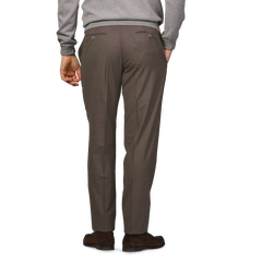 A person wearing a gray sweater and Canali's Brown Matte Wool Flat Front Trousers is standing with their back facing the camera.