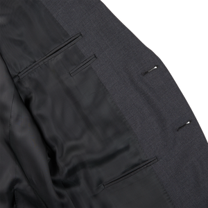 A close up of a Canali Charcoal Grey Wool Notch Lapel Suit with black buttons.