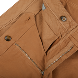 A close up of a pair of Canali Terracotta Cotton Stretch Flat Front Chinos with zippers, showcasing their distressed appearance.