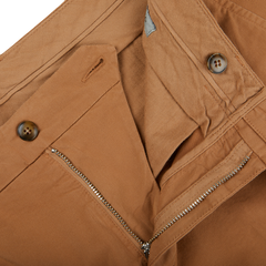 A close up of a pair of Canali Terracotta Cotton Stretch Flat Front Chinos with zippers, showcasing their distressed appearance.