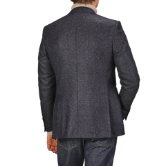 A person facing away, clad in the Canali Dark Blue Checked Wool Drop 6 Blazer, paired with jeans.