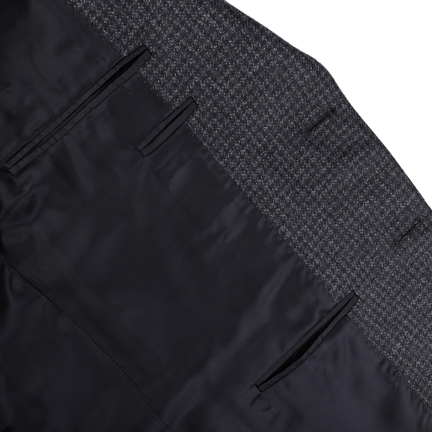 Detailed view of the inner lining of a dark blue checked business suit jacket made from 100% wool. This Canali Drop 6 Blazer showcases a silky black interior and inner pockets, combining elegance with functionality.