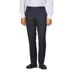 A person in a white shirt, Canali Dark Blue Melange Wool Flat Front Trousers with customizable length, and black loafers stands against a plain background.