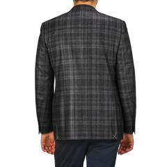 The man is dressed in a Canali Dark Grey Checked Wool Silk Drop 6 Blazer, radiating Milanese style as he stands against a plain background, viewed from the back.