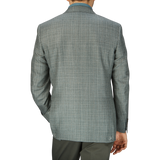 Rear view of a man wearing a Canali Green Checked Wool Silk Linen Blazer and dark trousers, standing against a plain background.