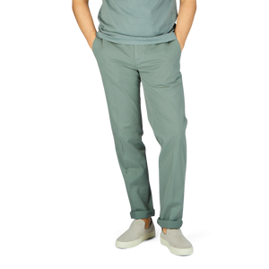 A man wearing Canali sage green cotton stretch flat front chinos and a white t-shirt.