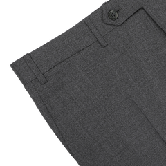 Close-up of the upper section of Canali's Grey Melange Wool Flat Front Trousers, featuring a button and belt loops, displayed on a white surface.