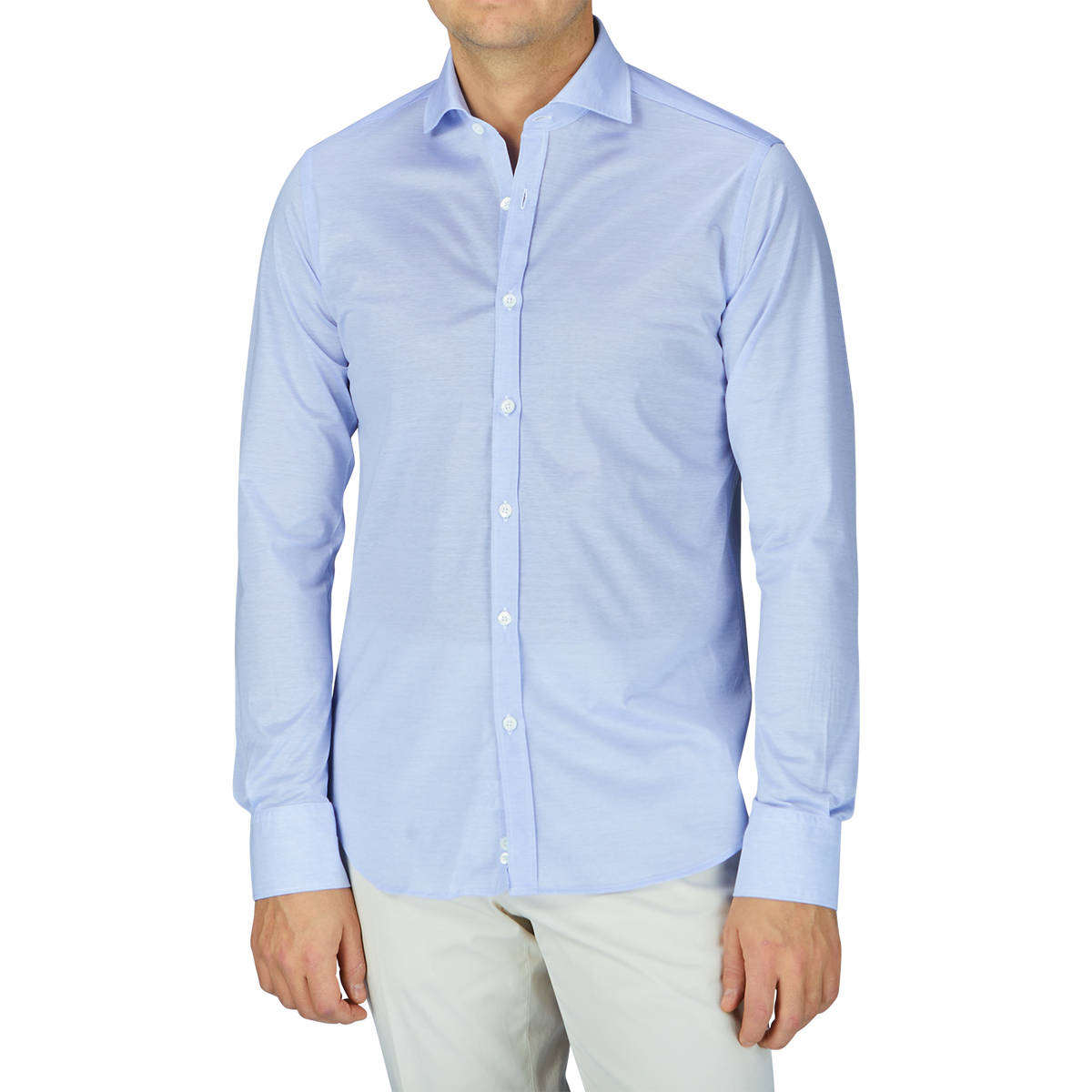 A contemporary man wearing a Canali Light Blue Cotton Jersey Casual Shirt and white pants.