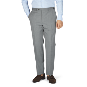 A man wearing Canali Light Grey Micro Check Wool Trousers with a blue shirt.