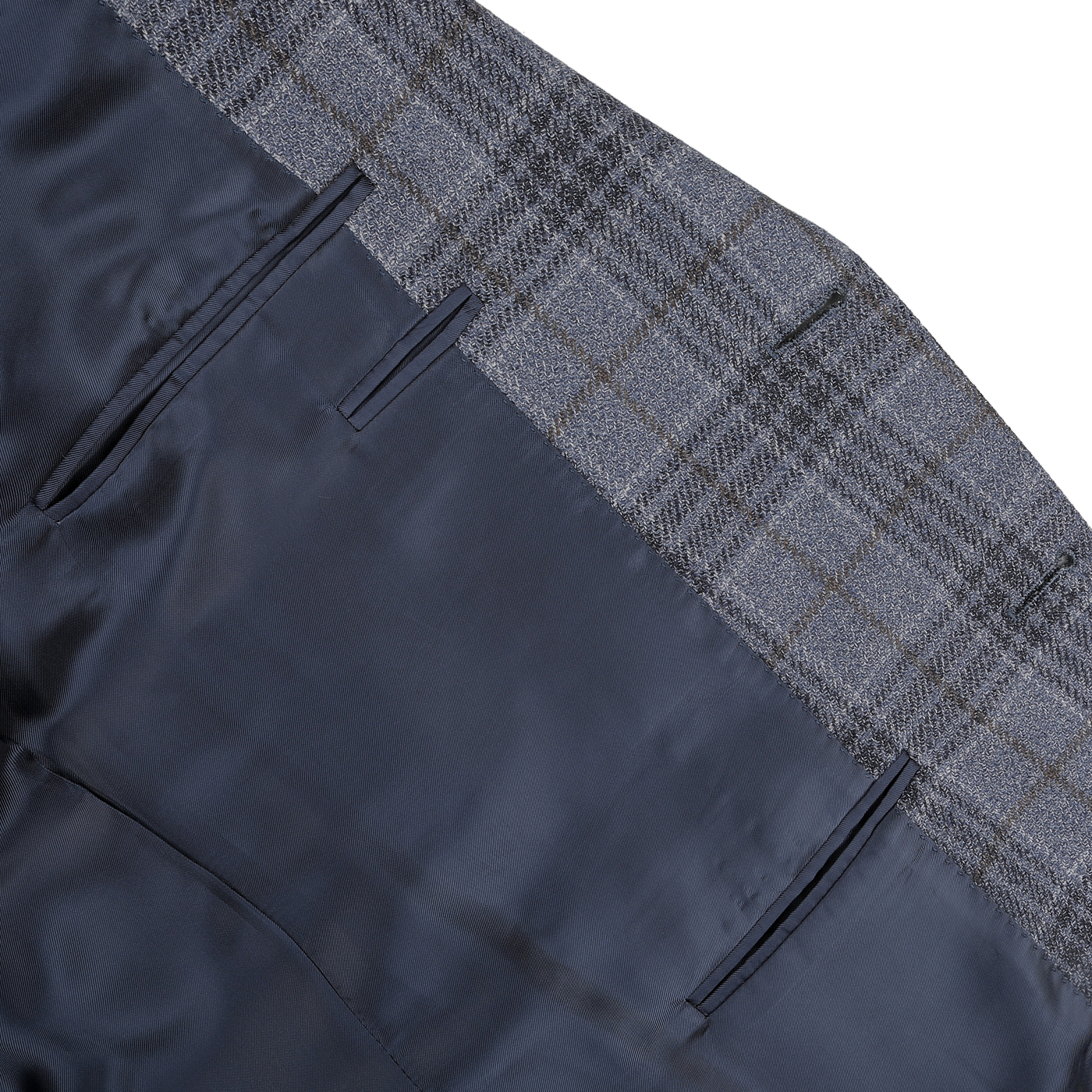 Close-up of the Mid Blue Checked Wool Silk Drop 6 Blazer by Canali, highlighting a plaid-patterned waistband and dark blue fabric in a wool-silk blend, featuring two pockets.