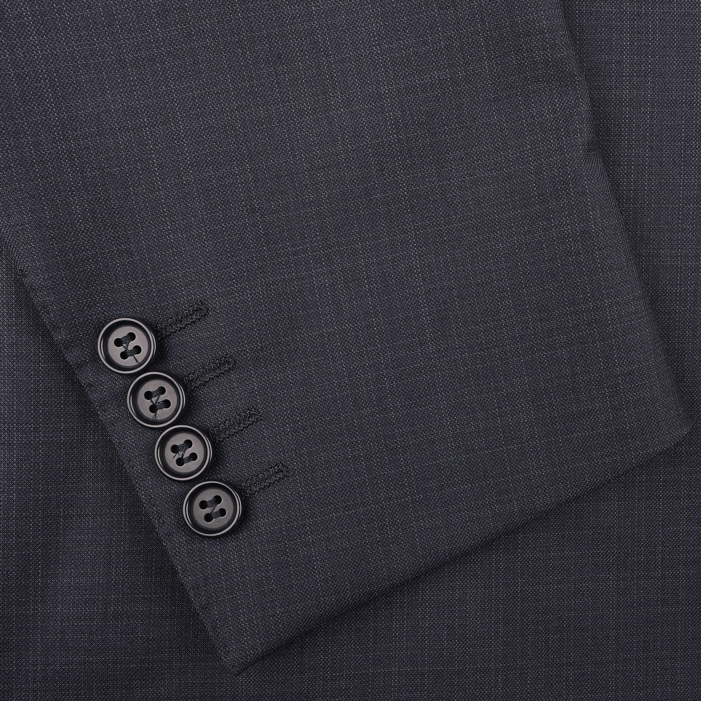 Close-up of a navy blue wool suit sleeve by Canali with four black buttons on the cuff, reflecting classic sartorial elegance.