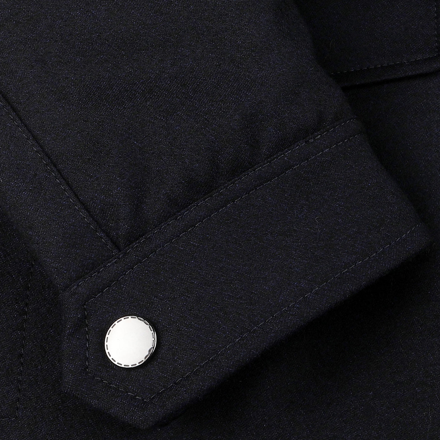 Close-up of a black shirt cuff with a white button, perfectly complementing the Canali Navy Blue Wool Fur Collar Bomber Jacket.