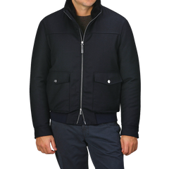 A person wearing the Canali Navy Blue Wool Bomber Jacket, featuring a detachable beaver fur collar, along with dark pants stands against a plain background.