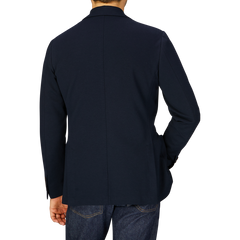 Man from behind wearing a Canali navy cotton jersey unconstructed blazer crafted with casual tailoring and denim jeans.