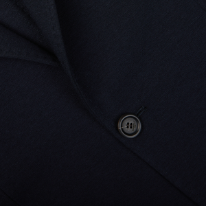 Close-up of a dark button on a Canali navy blue cotton stretch jersey garment.