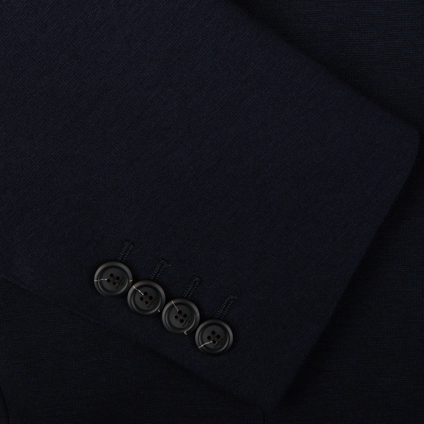 Close-up of a dark fabric with a row of four buttons, likely part of a Canali Navy Cotton Jersey Unconstructed Blazer.