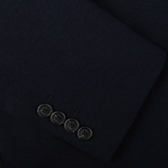 Close-up of a dark fabric with a row of four buttons, likely part of a Canali Navy Cotton Jersey Unconstructed Blazer.