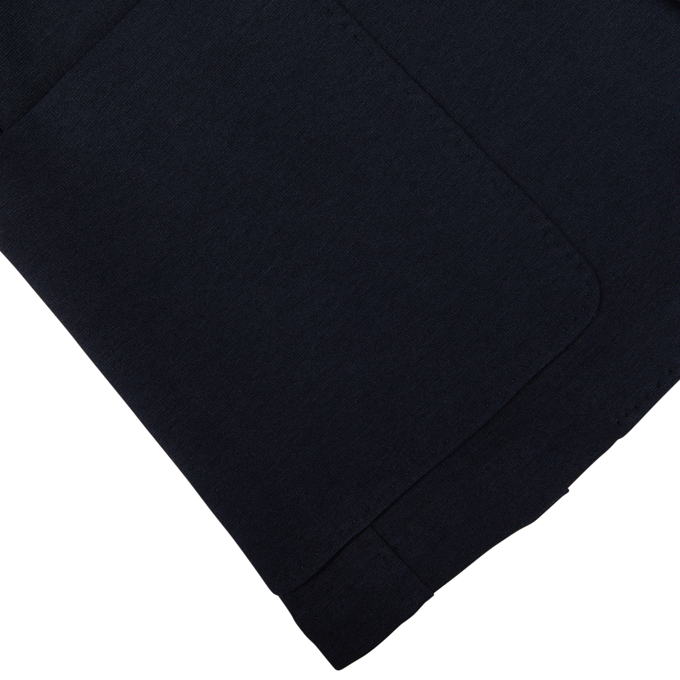 Navy blue cotton stretch jersey fabric with a folded edge on a white surface, Canali's Navy Cotton Jersey Unconstructed Blazer is versatile and stylish.