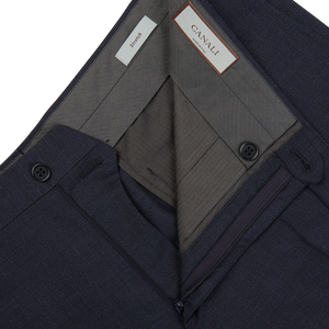 A pair of Canali Navy Puppytooth Wool Stretch Flat Front Trousers with a pocket on the side crafted from wool fabric.