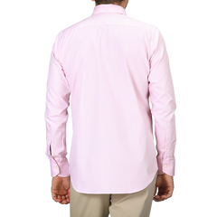 A person dressed in a Pink Cotton Single Cuff Shirt by Canali and beige pants is shown from the back against a white background.