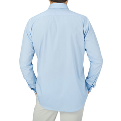 The back view of a man wearing a Canali Plain Blue Cotton Poplin Single Cuff Shirt made of ultra-soft cotton.