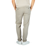 The man is wearing Stone Beige Cotton Stretch Flat Front Chinos by Canali, showcasing a stylish and sophisticated look.