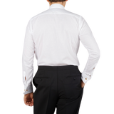The back view of a man wearing the Canali White Cotton Double Cuff Pleated Dress Shirt.