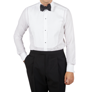 A man wearing a formal Canali White Cotton Double Cuff Pleated Dress Shirt and black pants.