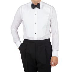 A man wearing a formal Canali White Cotton Double Cuff Pleated Dress Shirt and black pants.