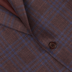 Close-up of a Canali wine-red checked fabric with a visible button, likely from a blazer.
