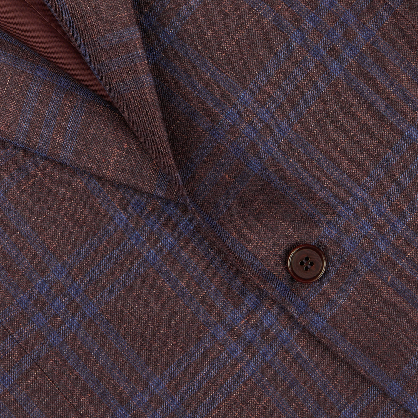 Close-up of a Canali wine-red checked fabric with a visible button, likely from a blazer.