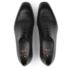 A pair of Carmina's Black Calf Leather Wholecut Rain Oxford Shoes, viewed from above, featuring a polished finish and laces that showcase the elegance of Goodyear welted construction.