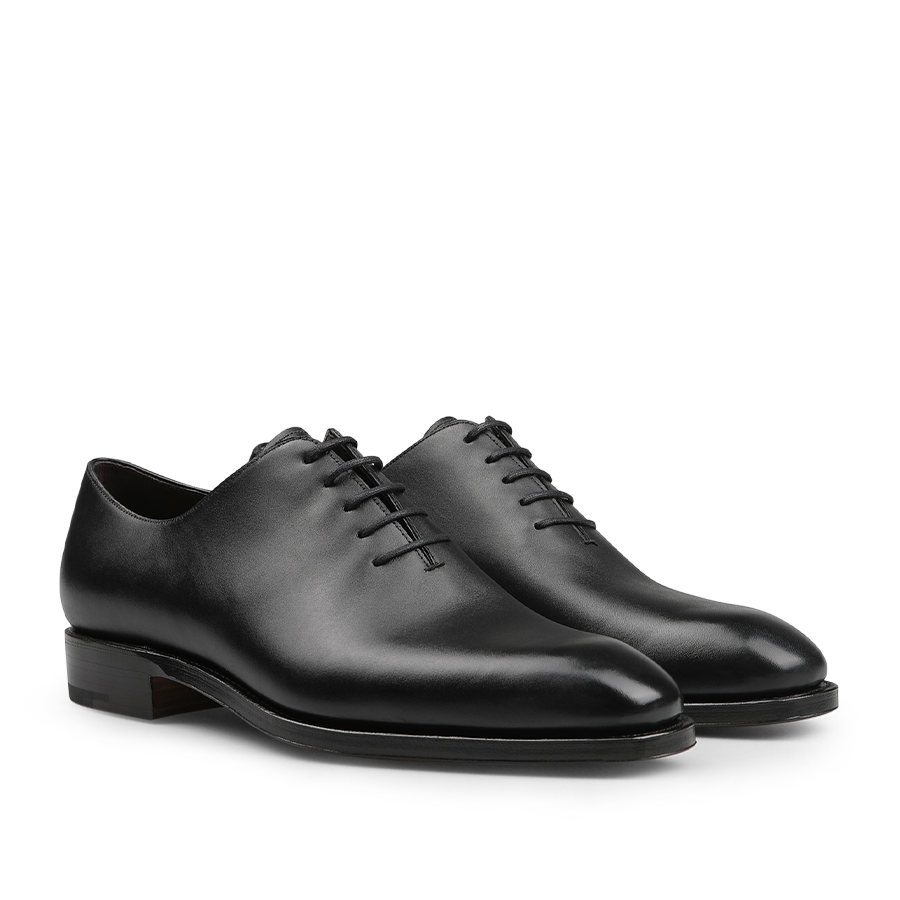 The Carmina Black Calf Leather Wholecut Rain Oxford Shoes are expertly crafted with premium calf leather, featuring round toes and closed lacing, along with a Goodyear welted construction that is visible from the side.