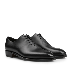 The Carmina Black Calf Leather Wholecut Rain Oxford Shoes are expertly crafted with premium calf leather, featuring round toes and closed lacing, along with a Goodyear welted construction that is visible from the side.