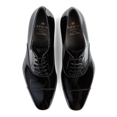 A pair of black, polished, Goodyear welted, lace-up Carmina dress shoes.