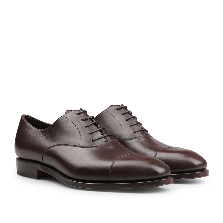 A pair of Carmina Brown Calf Rain Captoe Oxford Shoes with laces and a cap-toe design, showcasing craftsmanship inspired by Charles Goodyear, viewed from an angle.