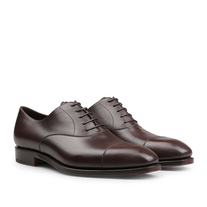 A pair of Carmina Brown Calf Rain Captoe Oxford Shoes with laces and a cap-toe design, showcasing craftsmanship inspired by Charles Goodyear, viewed from an angle.