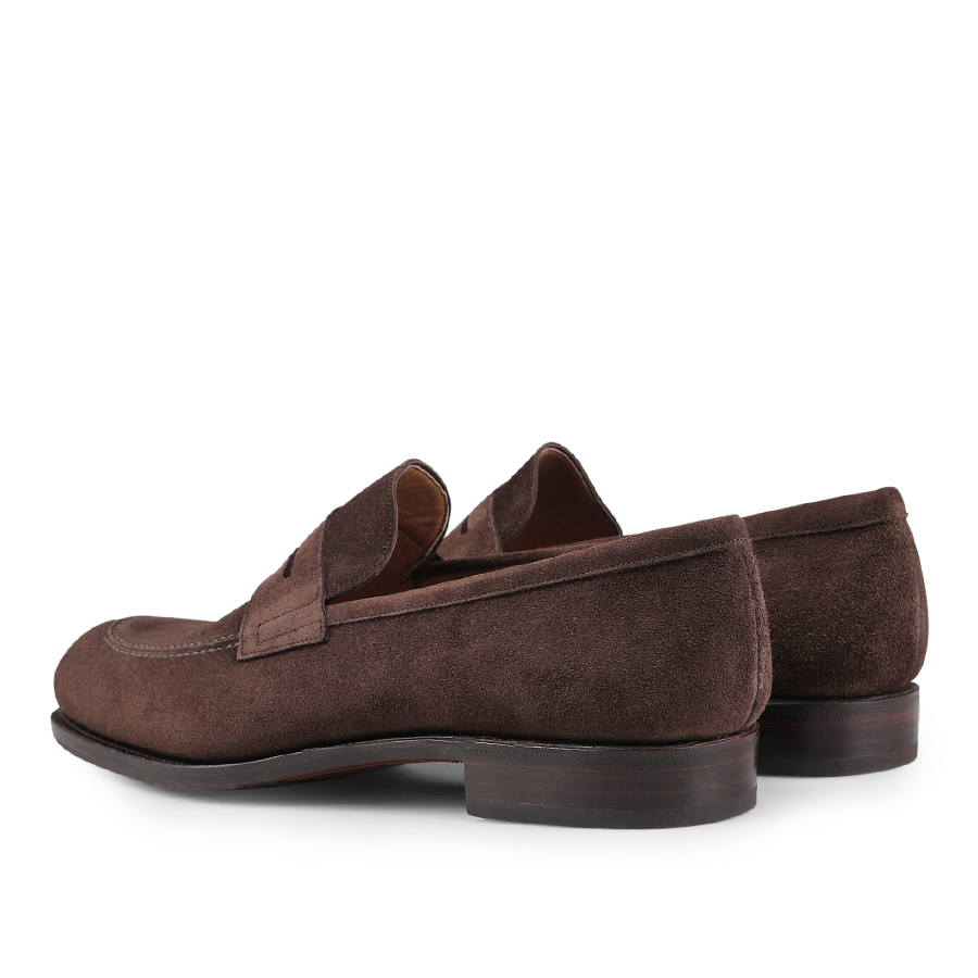 The Carmina Brown Suede Forest Rubber Penny Loafers, featuring stacked heels and a durable rubber sole for enhanced comfort and longevity, are displayed from a back angle against a white background.