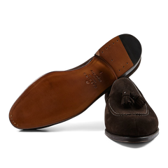 A pair of Brown Suede Forest Tassel Loafers with leather soles crafted by expert craftsmen, displayed on a transparent background, made by Carmina.