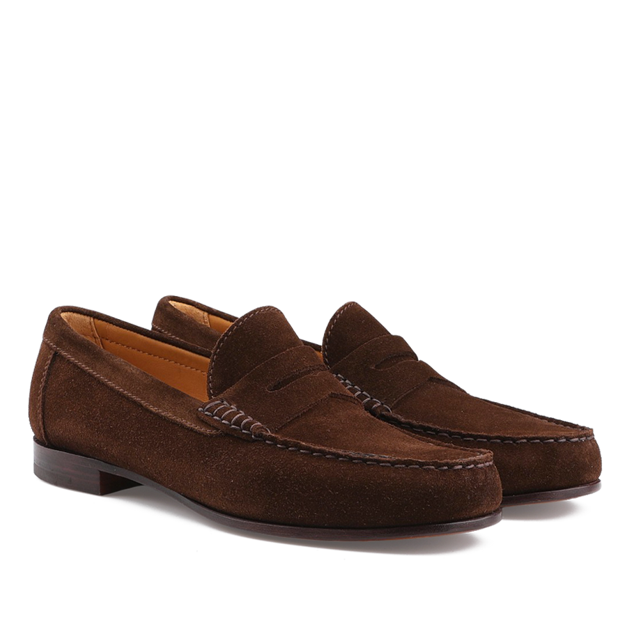 The Chocolate Repello Suede Xim Penny Loafers by Carmina feature a low heel, slip-on design, Blake rapid construction, and stitching details. They are shown on a white background.