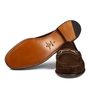 A pair of brown Carmina Chocolate Suede Leather Xim Horsebit Loafers on a transparent background.