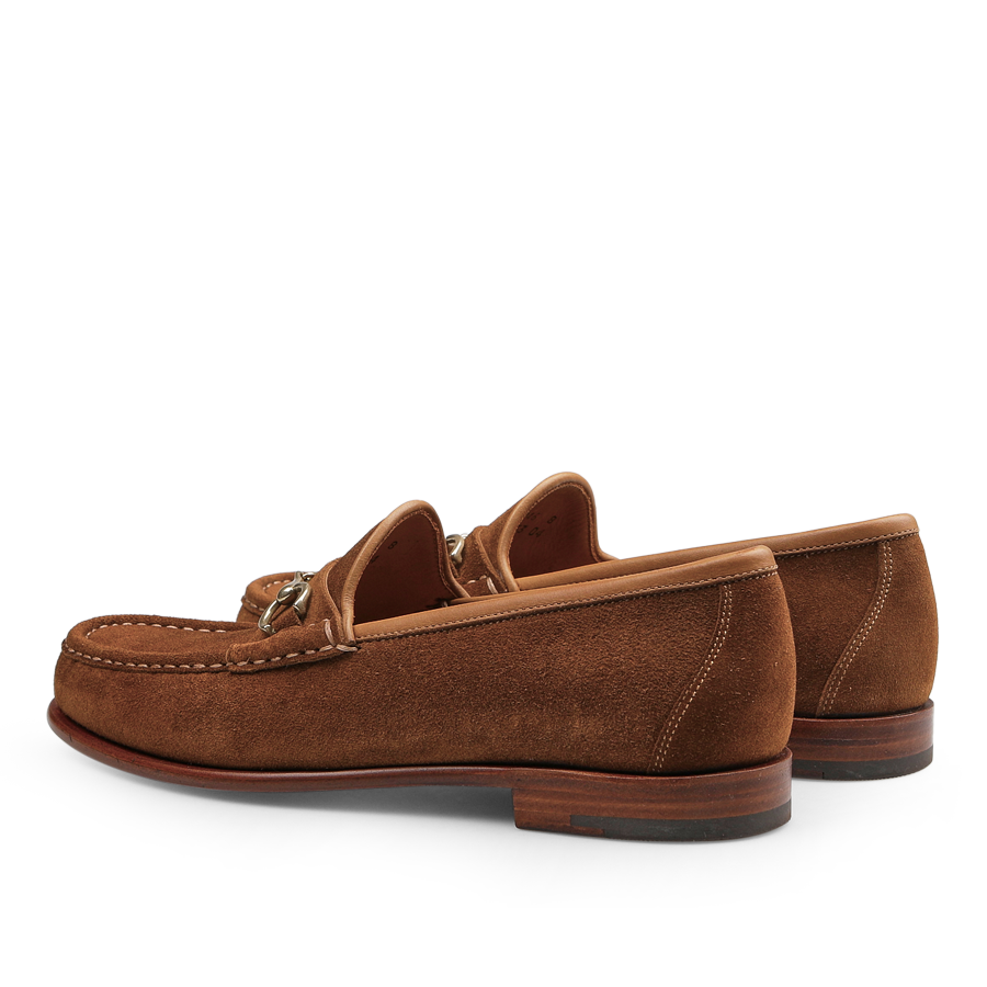 The Tobacco Suede Leather Xim Horsebit Loafers by Carmina are showcased in a sophisticated side view, emphasizing the intricate stitching details and elegant wooden soles, capturing the essence of Carmina's craftsmanship.