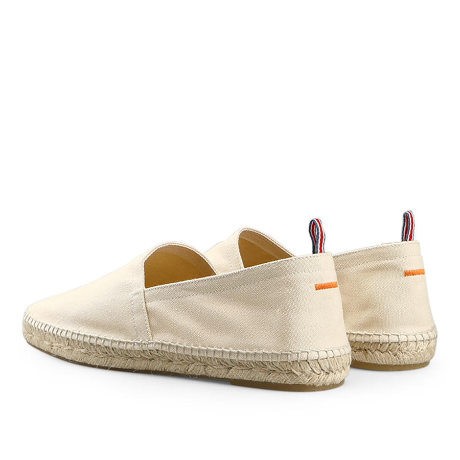 The Castañer Ivory Beige Cotton Pablo Espadrilles feature a woven sole, a small orange stripe, and a striped pull tab on the back, making them perfect to pair with denim blue cotton shorts for a classic summer look.