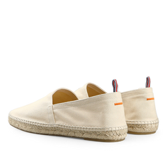 The Castañer Ivory Beige Cotton Pablo Espadrilles feature a woven sole, a small orange stripe, and a striped pull tab on the back, making them perfect to pair with denim blue cotton shorts for a classic summer look.