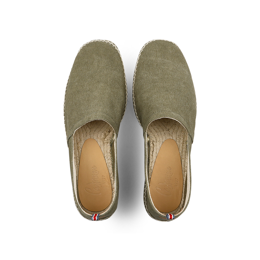 The Castañer Olive Green Cotton Canvas Pablo Espadrilles boast a woven sole of cotton and jute, with a red, white, and blue tag detail at the heel.